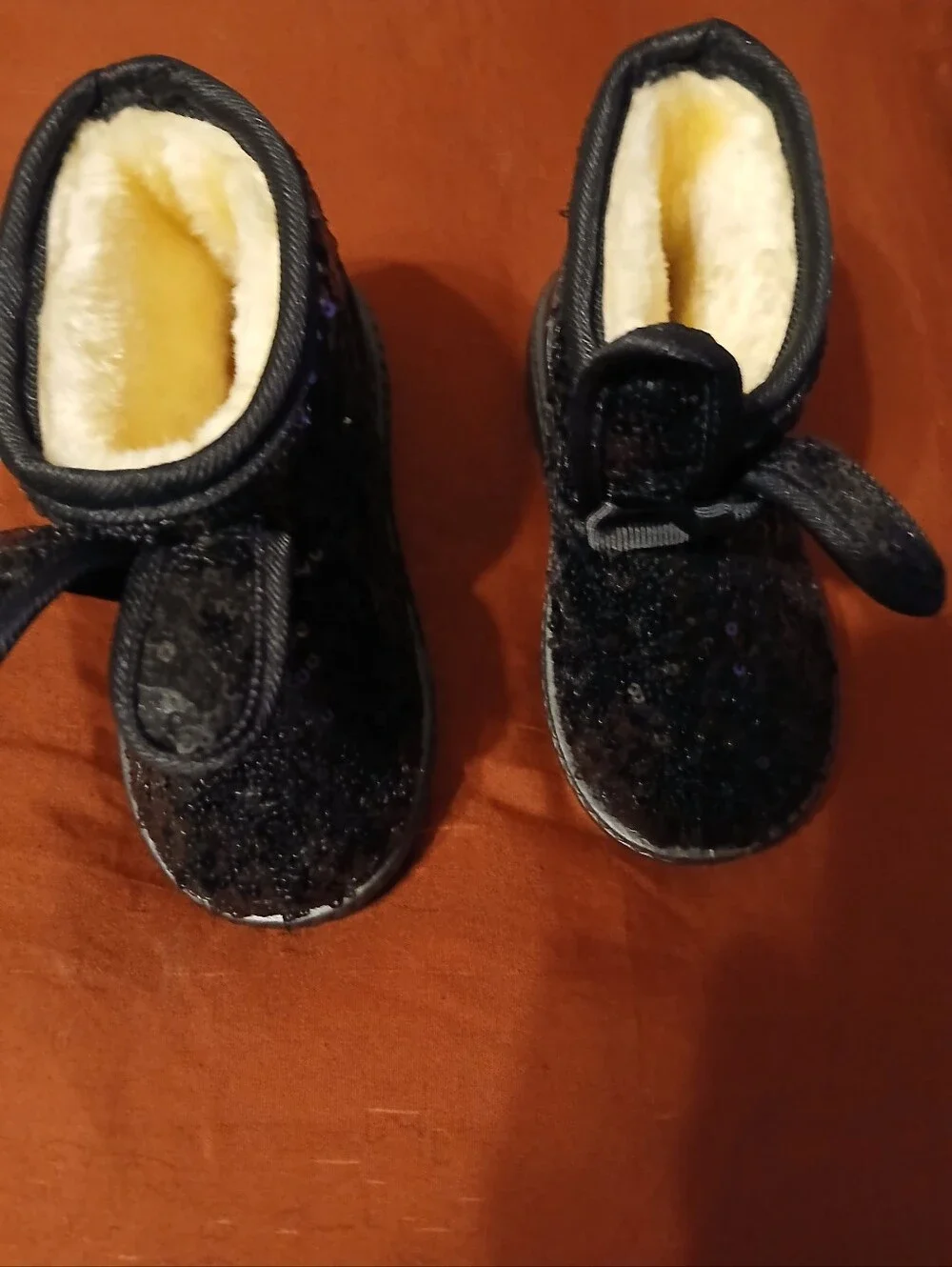 black sequin children's ankle boots with decorative bows and flat fur sole